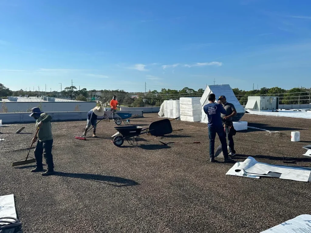 Trust Roofing team working on a commercial flat roof with beautiful blue Tampa Bay blue sky in the background