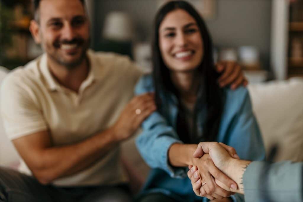 Happy man and woman clients handshake close deal with a contractor